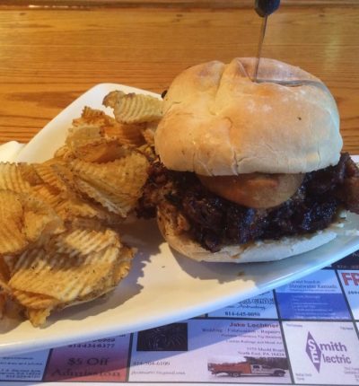 A plate featuring a sandwich alongside a serving of chips.